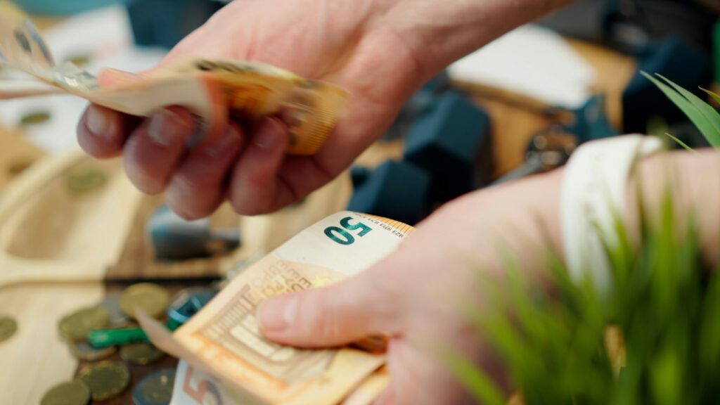 A closeup view on a hand that is counting paper bills.