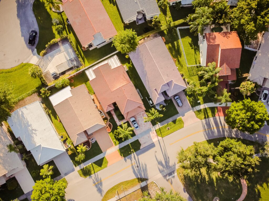 Top view of different houses with trees beside the houses.