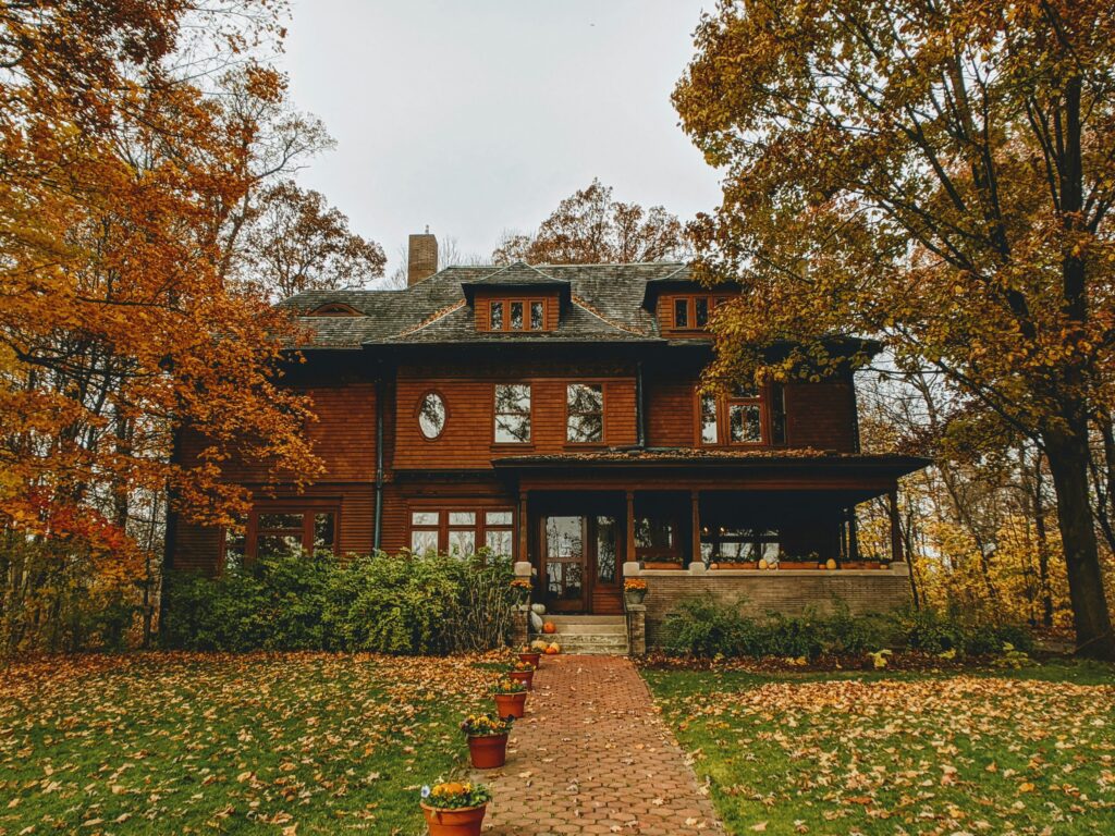 Front view of a house in Indiana with Trees around the house and plants in pots.