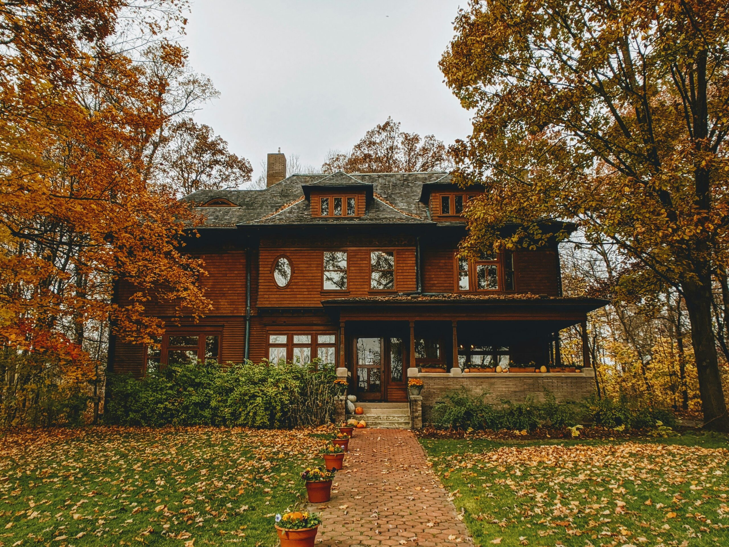 Front view of a house in Indiana with Trees around the house and plants in pots.
