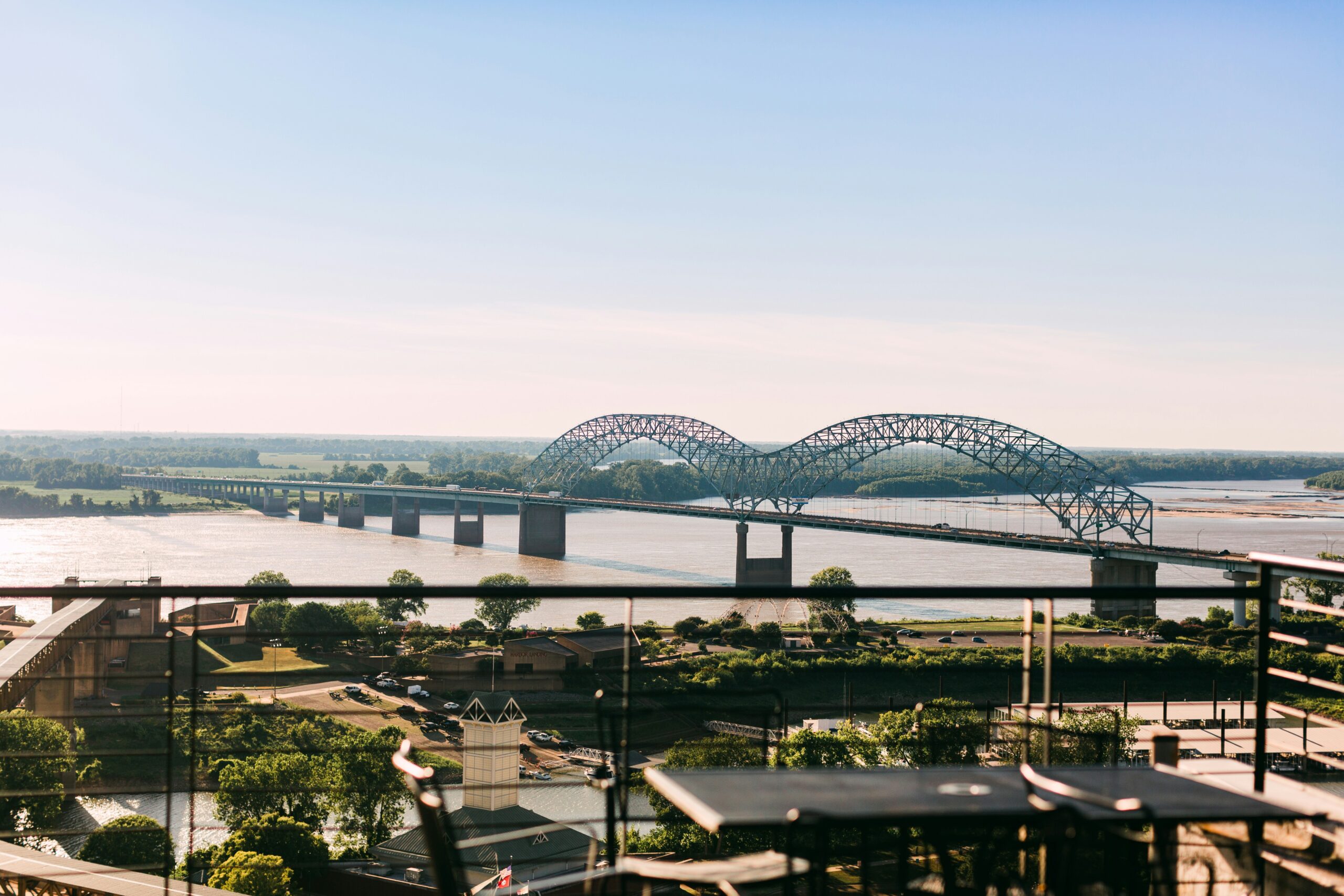 A landscape view of mississippi river with the bridge and the sky on the background.