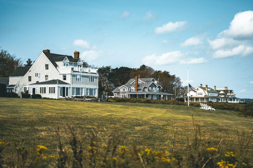A landscape view of three houses in Rhode Island with the sky on the background.
