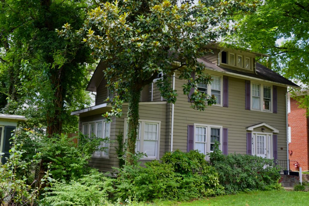 A photo of a house in Maryland with trees and plants all over it.