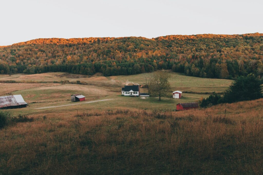 Landscape view of Tennessee hills with five houses, trees and the sky.