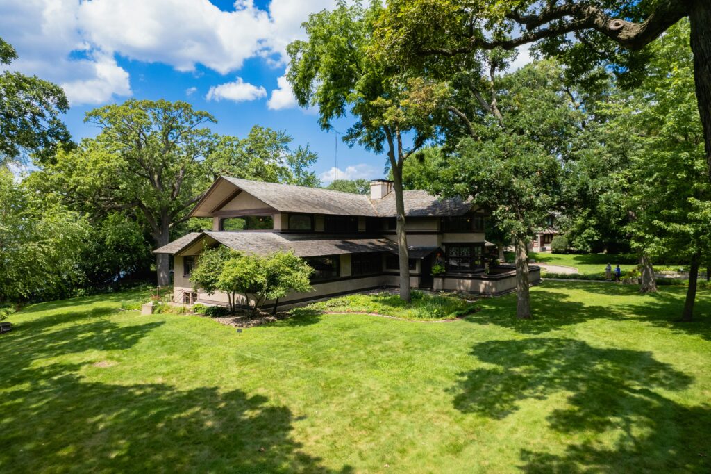 A beautiful house in Illinois surrounded by large trees and green grass lawn.